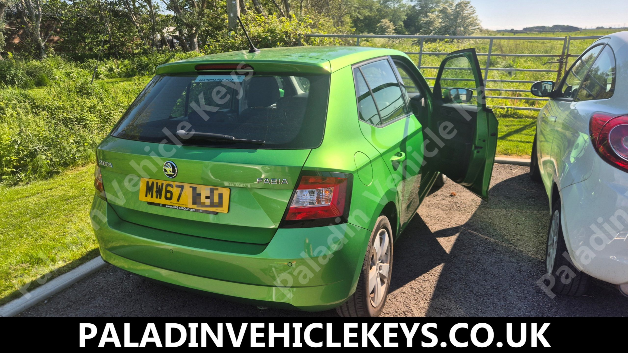 Bright green Skoda Fabia parked in a rural lot with rear hatch and right doors open; watermark for PaladinVehicleKeys.co.uk across image.